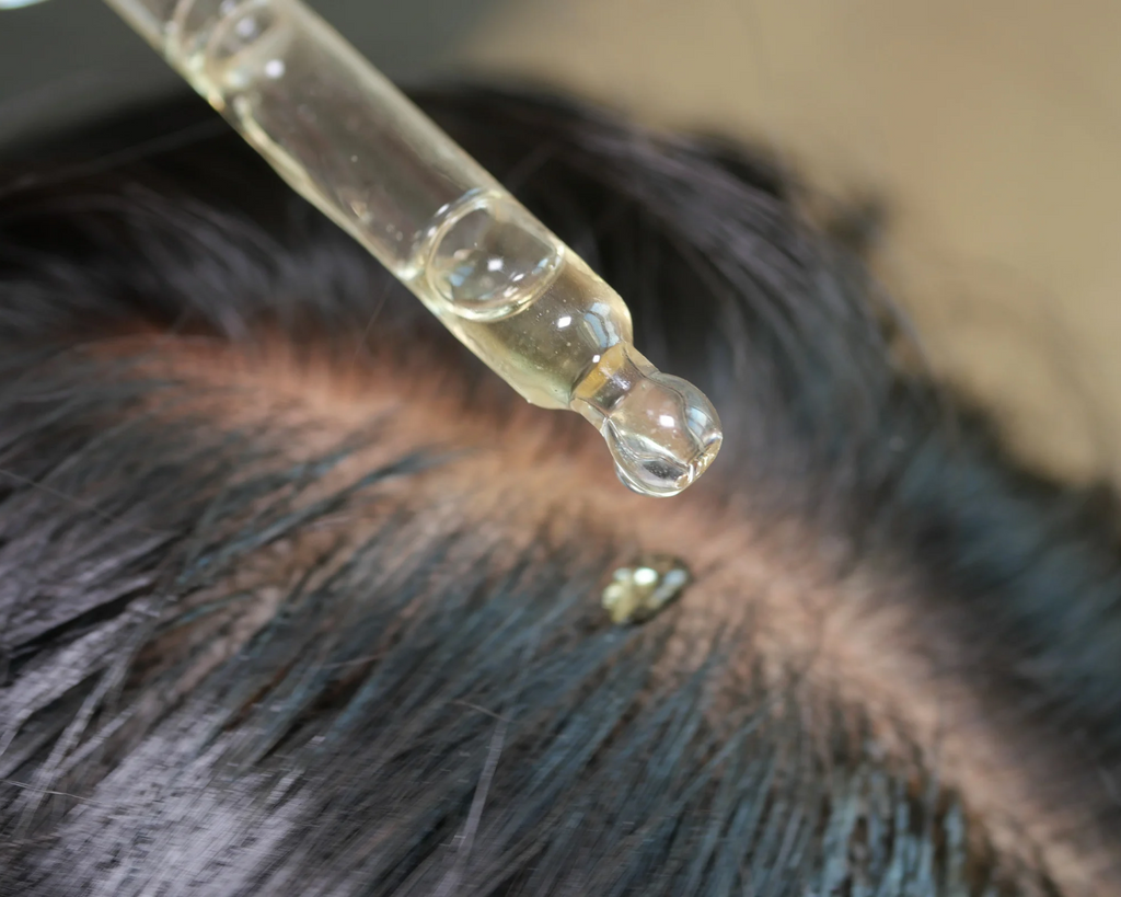 Applying a lightweight scalp serum with a dropper to the scalp as part of a daily scalp care routine